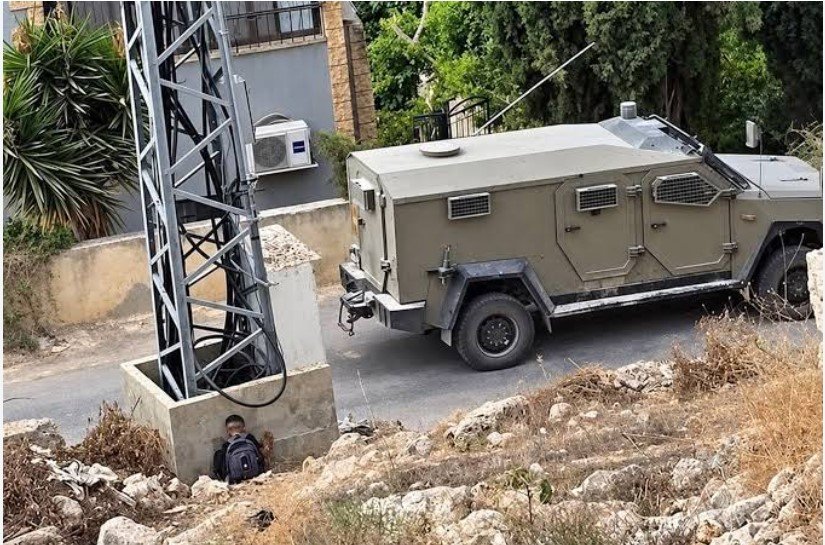 طفل فلسطيني يختبئ خلف عمود خوفا